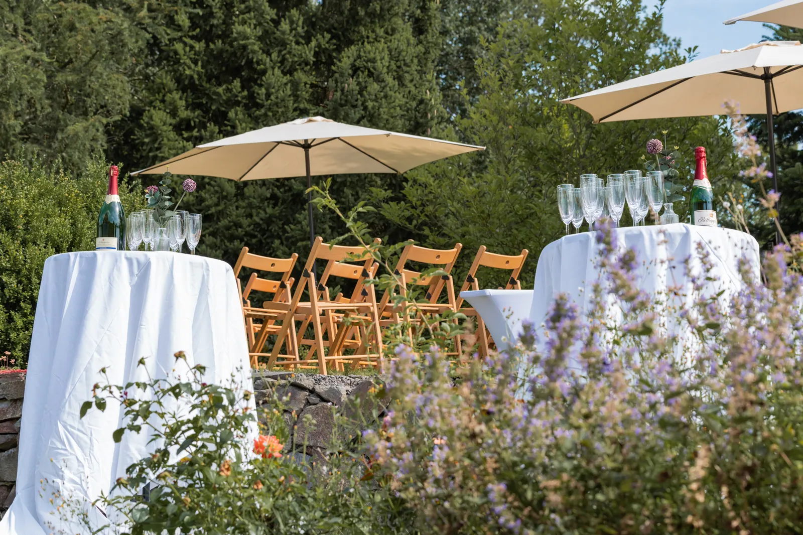 Stehtische mit Sonnenschirmen im Garten