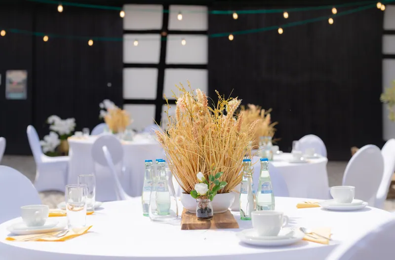 Gedeckter Tisch mit Getreidedekoration im Hof